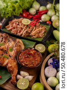 Grilled chicken on a plate with chili peppers, garlic sauce and sprinkled with pepper seeds. Стоковое фото, агентство Ingram Publishing / Фотобанк Лори