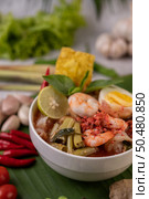 Tom Yum noodle with shrimp and boiled egg, accompanied by lime, cucumber, basil, eggplant and garlic. Стоковое фото, агентство Ingram Publishing / Фотобанк Лори