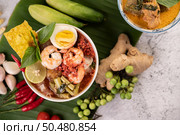 Tom Yum noodle with shrimp and boiled egg, accompanied by lime, cucumber, basil, eggplant and garlic. Стоковое фото, агентство Ingram Publishing / Фотобанк Лори