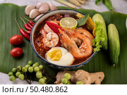 Tom Yum noodle with shrimp and boiled egg, accompanied by lime, cucumber, basil, eggplant and garlic. Стоковое фото, агентство Ingram Publishing / Фотобанк Лори