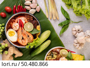 Tom Yum noodle with shrimp and boiled egg, accompanied by lime, cucumber, basil, eggplant and garlic. Стоковое фото, агентство Ingram Publishing / Фотобанк Лори