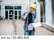 Architects hold floor plans and talk on the phone. Стоковое фото, агентство Ingram Publishing / Фотобанк Лори