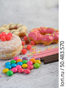 Donuts sprinkled with icing sugar and candy on a white background. Стоковое фото, агентство Ingram Publishing / Фотобанк Лори