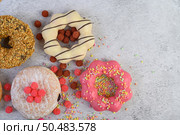 Donuts decorated icing and sprinkles on white background top view. Стоковое фото, агентство Ingram Publishing / Фотобанк Лори