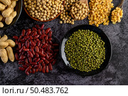 Legumes, and beans assortment on the black cement floor. Top view. Стоковое фото, агентство Ingram Publishing / Фотобанк Лори