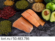 Legumes, fruit, and salmon placed on a black cement floor. Стоковое фото, агентство Ingram Publishing / Фотобанк Лори