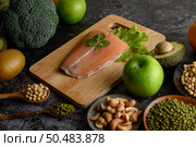 legumes, fruit, and Salmon fish pieces on a wooden chopping board. Стоковое фото, агентство Ingram Publishing / Фотобанк Лори