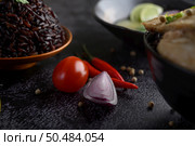 Purple rice berries in a bowl with red onions, chilli and tomatoes. Selective foucs. Стоковое фото, агентство Ingram Publishing / Фотобанк Лори