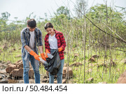 Men and women helped to collect garbage in a black bag. Стоковое фото, агентство Ingram Publishing / Фотобанк Лори