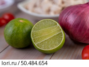 Half cut lemons and red onions placed on a wooden table. Selective focus. Стоковое фото, агентство Ingram Publishing / Фотобанк Лори
