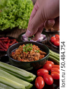 Sweet pork in a black bowl, complete with cucumbers, long beans, tomatoes, and side dishes. Selective focus. Стоковое фото, агентство Ingram Publishing / Фотобанк Лори