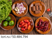 Palm sugar, red onions, dried peppers, tomatoes, cucumbers, yard long beans and lettuce in a bowl. Стоковое фото, агентство Ingram Publishing / Фотобанк Лори