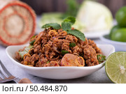 Spicy pork chops in a white dish consisting of lemons, chilies, and side dishes. Selective focus. Стоковое фото, агентство Ingram Publishing / Фотобанк Лори
