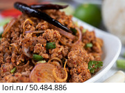 Spicy pork chops in a white dish consisting of lemons, chilies, and side dishes. Selective focus. Стоковое фото, агентство Ingram Publishing / Фотобанк Лори