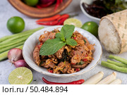 Spicy pork chops in a white dish consisting of lemons, chilies, and side dishes. Selective focus. Стоковое фото, агентство Ingram Publishing / Фотобанк Лори