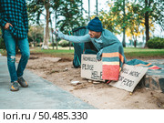 Beggars wrapped in cloth and then put on a hat and sat down beside the street and someone gave money. Стоковое фото, агентство Ingram Publishing / Фотобанк Лори