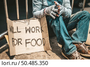 The man sitting begging on an overpass with messages homeless people please help and work well with food. Стоковое фото, агентство Ingram Publishing / Фотобанк Лори