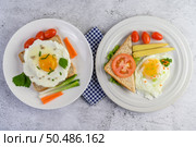 A fried egg laying on a toast, topped with pepper seeds with carrots, baby corn and spring onions. Стоковое фото, агентство Ingram Publishing / Фотобанк Лори