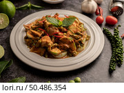 Dry green curry with chicken in white plates on black cement. Стоковое фото, агентство Ingram Publishing / Фотобанк Лори