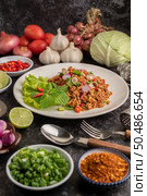 Spicy minced pork salad with chili flakes, lime, chopped green onions, chilli and roasted rice, sliced ??shallots on a cement floor. Стоковое фото, агентство Ingram Publishing / Фотобанк Лори