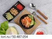 Thai papaya salad in a white plate with Spoon, fork, and dried shrimp. Стоковое фото, агентство Ingram Publishing / Фотобанк Лори