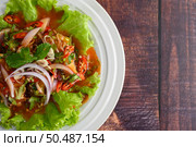 Top view Spicy salad of sardine with tomato sauce mixed with herb and lemon, beautiful decoration by lettuce leaf inviting to hungry in white dish,  copy space. Стоковое фото, агентство Ingram Publishing / Фотобанк Лори