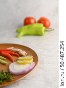 Vertical Image, Selective focus canned sardine with tomato sauce pepermint on top and cooking ingredient was arrangement in wooden tray, blurred green chili and tomato, copy space. Стоковое фото, агентство Ingram Publishing / Фотобанк Лори