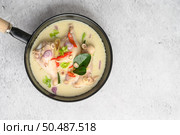 Tom Kha Kai in a pan frying with kaffir lime leaves, lemongrass, red onion, galangal and chilli. Top view. Стоковое фото, агентство Ingram Publishing / Фотобанк Лори