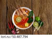 Tom Yum Kung Thai hot spicy soup shrimp with lemon grass,lemon,galangal and chilli on wooden background Thailand Food. Стоковое фото, агентство Ingram Publishing / Фотобанк Лори