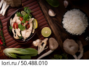 Boil the fish infusion with tomatoes, mushrooms, coriander, spring onion and lemongrass in a bowl. Стоковое фото, агентство Ingram Publishing / Фотобанк Лори