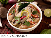 Boil the fish infusion with tomatoes, mushrooms, coriander, spring onion and lemongrass in a bowl. Стоковое фото, агентство Ingram Publishing / Фотобанк Лори