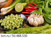 Long beans, garlic, chili, lime, scallion and cha-om are placed on a wooden table. Стоковое фото, агентство Ingram Publishing / Фотобанк Лори
