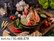 Tom Yum Kung in a bowl with tomato, chili, lemongrass, garlic, lemon, and kaffir lime leaves. Стоковое фото, агентство Ingram Publishing / Фотобанк Лори