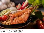 Tom Yum Kung in a bowl with tomato, chili, lemongrass, garlic, lemon, and kaffir lime leaves. Стоковое фото, агентство Ingram Publishing / Фотобанк Лори