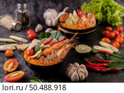 Tom Yum Kung in a bowl with tomato, chili, lemongrass, garlic, lemon, and kaffir lime leaves. Стоковое фото, агентство Ingram Publishing / Фотобанк Лори