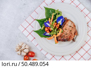 Pork Steak with Tomato, Carrot, Red Onion, Peppermint, Butterfly Pea Flower, and Lime. Стоковое фото, агентство Ingram Publishing / Фотобанк Лори