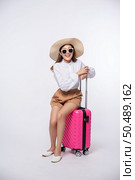 Woman wearing a hat, glasses, and handles of suitcases to travel. Стоковое фото, агентство Ingram Publishing / Фотобанк Лори