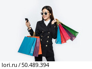 Young women wear glasses and shop on smart phones. Стоковое фото, агентство Ingram Publishing / Фотобанк Лори