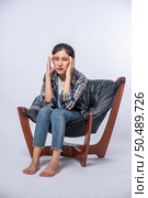 The woman was sick, sat on a chair, and touched her head with her hand. Стоковое фото, агентство Ingram Publishing / Фотобанк Лори