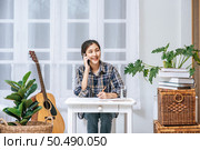 Women sit at the desk and use the phone to coordinate. Стоковое фото, агентство Ingram Publishing / Фотобанк Лори