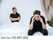 A woman who loves each other gets angry and sits on the bed. Стоковое фото, агентство Ingram Publishing / Фотобанк Лори
