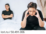 A woman who loves each other gets angry and sits on the bed. Стоковое фото, агентство Ingram Publishing / Фотобанк Лори