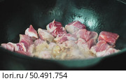 Searing beef chunks browning in seasoned cast iron skillet, releasing savory aromas while developing deep caramelized crust during high heat cooking process. Стоковое видео, видеограф Данил Руденко / Фотобанк Лори