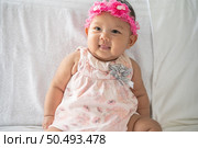 A baby learns to sit on a white bed. Стоковое фото, агентство Ingram Publishing / Фотобанк Лори