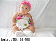 A baby learns to sit on a white bed. Стоковое фото, агентство Ingram Publishing / Фотобанк Лори