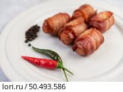 Sausage wrapped pork belly on a white plate. Selective focus. Стоковое фото, агентство Ingram Publishing / Фотобанк Лори