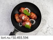 Sausage wrapped in pork belly in a pan with sesame and mint. Selective focus. Стоковое фото, агентство Ingram Publishing / Фотобанк Лори