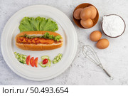 Sausage wrapped in bread and lettuce topped with sauce. Стоковое фото, агентство Ingram Publishing / Фотобанк Лори