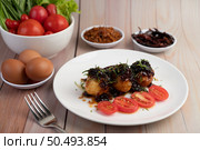 Boiled eggs stir-fried with tamarind sauce, topped with fried onions and dried chilies, son-in-law, Thai food. Стоковое фото, агентство Ingram Publishing / Фотобанк Лори