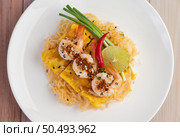 Fresh Pad Thai Shrimp with lime, lettuce, omelet and spring onions in a white plate on wooden. Стоковое фото, агентство Ingram Publishing / Фотобанк Лори